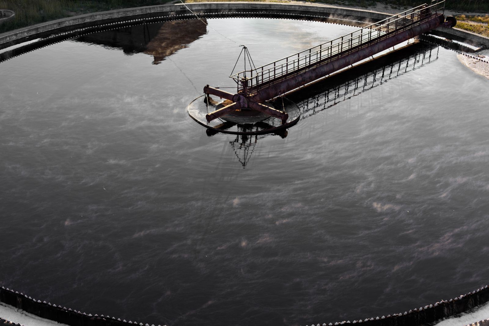 Wasseroberfläche eines Klärbeckens mit Räumerbrücke
